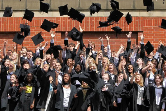 Students throw their mortarboards in the air during their graduation Students throw their mortarboards in the air during their graduation